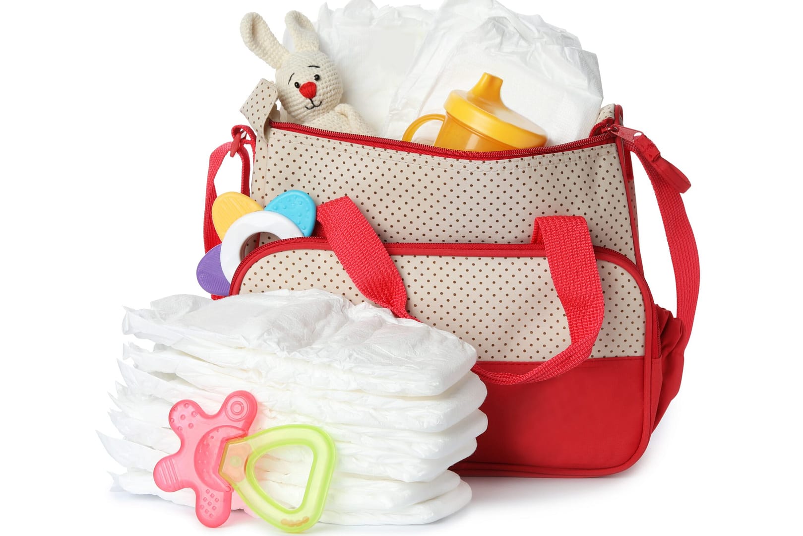 Maternity bag with disposable nappies and child's accessories on white background