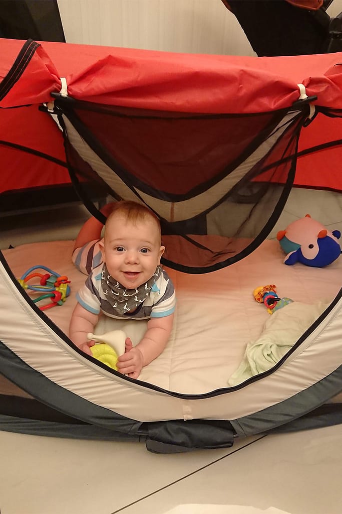 A picture of a baby in a travel cot